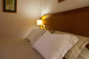 福莫苏村卢西塔诺酒店的一间卧室配有带白色枕头的床
