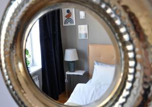 华沙Best Rest Warszawa Stare Miasto的镜子反射着卧室,卧室配有床和灯