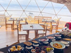 Salinas Grandes Jujuy - Pristine Luxury Camp的一张桌子,上面放着盘子,享有海滩美景