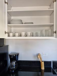 瓦利Bel Ti Plas的一个带餐具和杯子的厨房架