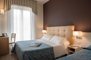 里米尼索尔米奥酒店的酒店客房设有床和窗户。