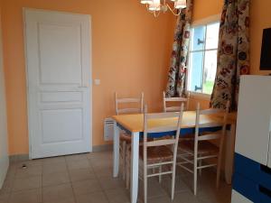 洛克马里亚Maison avec vue sur mer dans Résidence Marie Galante的一间带桌椅和门的用餐室