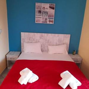 斯卡拉卡里拉奇斯Villa Marianna的一间卧室配有红色的床和两条白色毛巾
