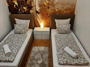 布尔诺Nobless Apartment Brno的配有灯的小客房内的两张床