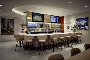 多瓦尔Holiday Inn & Suites Montreal Airport的餐厅里的酒吧,四周有凳子