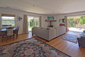 TryphenaFrosty's Retreat - Great Barrier Island Home的带沙发的客厅和用餐室