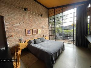 圣保罗Degar Studios的一间卧室设有一张床和砖墙