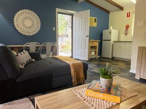 赫维湾Colonial Village Resort的一间带黑色沙发的客厅和一间厨房