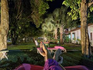 帕里普埃拉Villa Ostello Pousada的夜间躺在公园吊床上的人