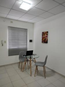 雷西斯膝西亚Departamento Temporario的配有桌子、两把椅子和一台笔记本电脑的房间