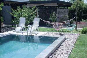 查克拉斯德科里亚Refugio Padma的庭院内带椅子和吊床的游泳池