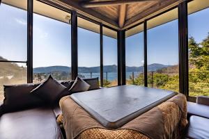箱根VILLA HAKONE湖空的窗户前配有桌椅的房间