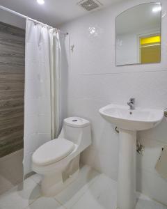 圣多明各Malecon Rooms y Hotel的白色的浴室设有卫生间和水槽。