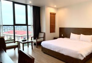 海防HOTEL Blue Rose的一间卧室设有一张床和一个大窗户