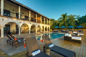 珀拉什奇亚Mariposa Belize Beach Resort的一个带游泳池和椅子的度假胜地和一座建筑