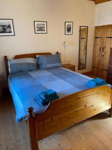 阿平港The Old Ferryhouse的卧室内一张带蓝色床单的大型木质床