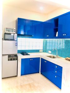 沙努尔Ocean Star Apartment Sanur的蓝色的厨房配有白色家电和蓝色瓷砖