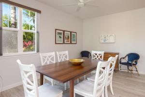瓦克拉Waikoloa Colony Villas #2105的一间带木桌和白色椅子的用餐室