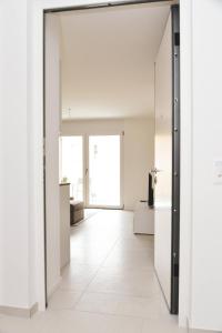 阿格诺Brand New Apartmentcecilia Residence Apt N5的开放式走廊设有白色墙壁和推拉门