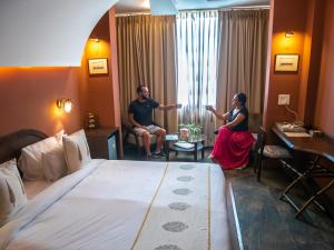 阿格拉Ekaa Villa near Taj Mahal的坐在酒店房间的男女