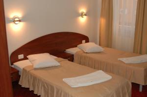 阿拉德艾瑞斯酒店的酒店客房,配有两张带白色床单的床