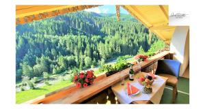 盖洛斯Heimat Apartments - Zillertal的阳台配有桌子,享有森林美景