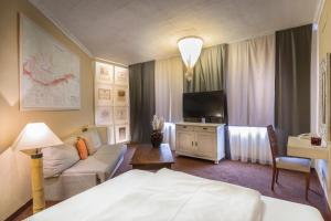 布拉格优雅酒店的酒店客房配有床、沙发和电视。
