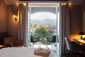 基茨比厄尔ERIKA Boutiquehotel Kitzbühel的酒店客房设有一张床,享有阳台的景色