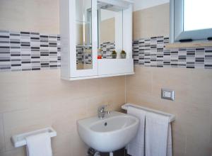 伊索拉迪卡波里祖托B&B Capo Rizzuto fronte Mare的浴室配有盥洗盆、镜子和毛巾