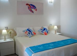伊索拉迪卡波里祖托B&B Capo Rizzuto fronte Mare的卧室配有白色床和蓝色及白色枕头