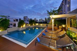 曼谷Ramada by Wyndham Bangkok Ten Ekamai Residences的建筑物屋顶上的游泳池