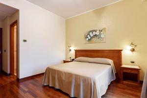 Bagnoli del Trigno多莫斯酒店的卧室配有白色的床和2张桌子