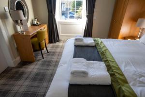 卡伦德韦弗利酒店的两张位于酒店客房的床,配有毛巾