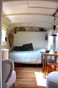 De PasPipowagen Lent的卧室配有一张床和一张桌子及椅子