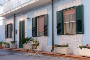 马尔扎梅米Stella Maris Marzamemi Apartments的前面有绿色百叶窗和植物的房子