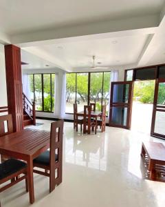 古莉Beach Walk Villa Maldives的用餐室设有桌椅和窗户。
