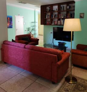 海法Hostel Roks的客厅配有红色沙发和电视