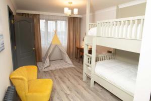 GeesalaErris Coast Hotel的儿童卧室配有双层床和椅子