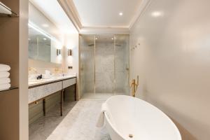 阿姆斯特丹Hotel 717的白色的浴室设有浴缸和淋浴。