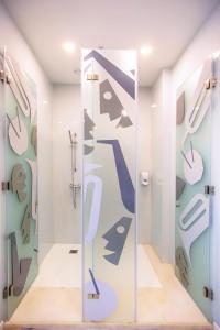 阿尔布费拉Musical Hostel的浴室设有玻璃门和卫生间壁画