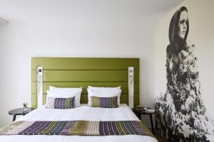 杜塞尔多夫杜塞尔多夫胜利广场靛蓝酒店的一间卧室配有一张带绿色床头板的床