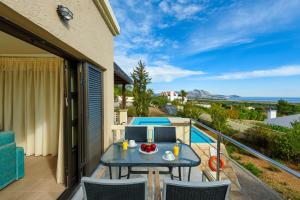 卡拉索斯Aegean Blue Villa's - All Inclusive & Water park的阳台的天井配有桌椅