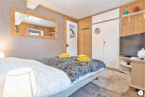 圣热尔韦莱班CHAMBRE INDÉPENDANTE avec SALLE DE BAIN INDÉPENDANTE au RDC d un chalet à 25 kms Chamonix的一间卧室配有一张床和一台平面电视