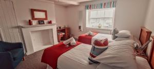 奇切斯特Itchenor Sailing Club的一间卧室设有两张床和一个壁炉