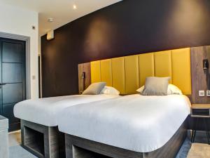 塔姆沃思OYO Tamworth Arms Boutique Pub & Hotel的一间卧室配有一张白色大床和黄色床头板