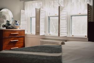 温莎大瀑布Hill Road Manor Bed & Breakfast的卧室设有白色百叶窗和1张床