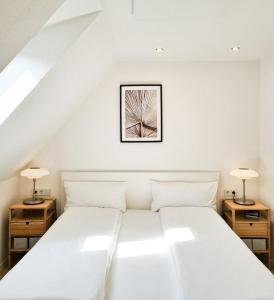 鲁斯特Mirielle Apartments的卧室配有带两盏灯的白色床