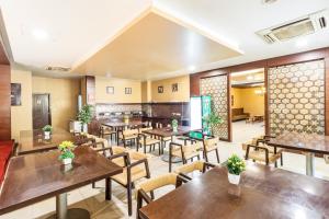 班加罗尔Octave Himalaya Monarch的配有木桌和椅子的餐厅
