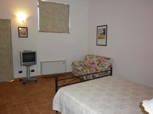 圣吉米纳诺珀德利乐格罗特酒店的配有床、椅子和电视的房间