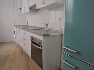 穆尔西亚Apartamento Garcar的厨房配有白色橱柜和蓝色冰箱。